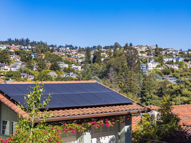 Detached home with a tiled roof and rooftop solar panels