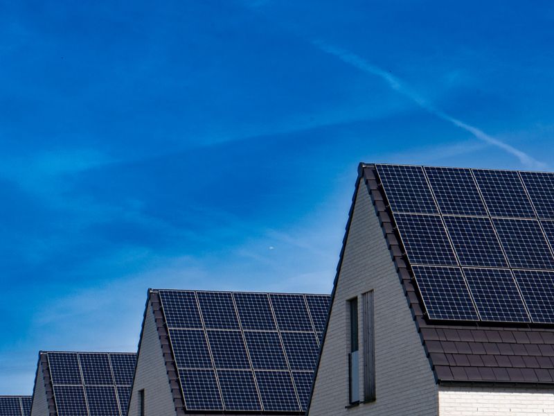 Contemporary houses with rooftop solar panels under a clear sky