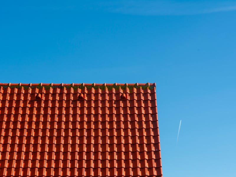Newly tiled residential roof against a clear blue sky